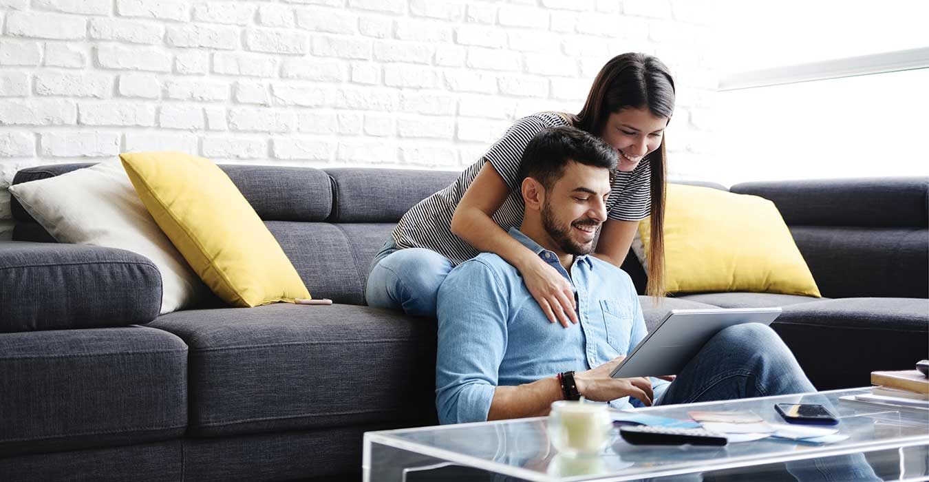 Couple on a sofa looking at an online application.