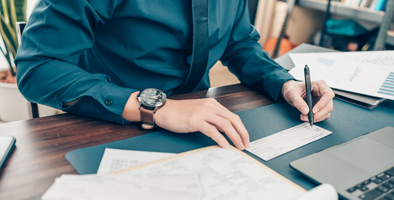 Close-up of man writing a check