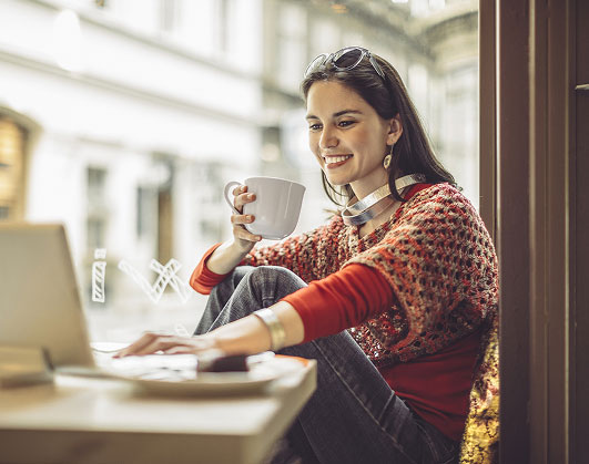 Young woman using laptop in coffee shop