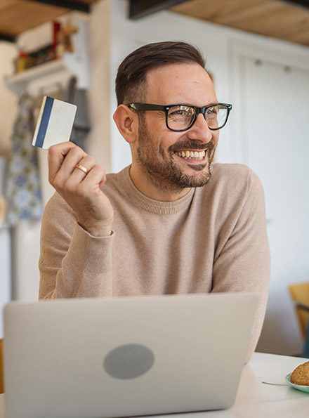 Man using debit card on laptop