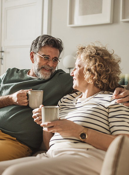Mature couple having coffee in living room