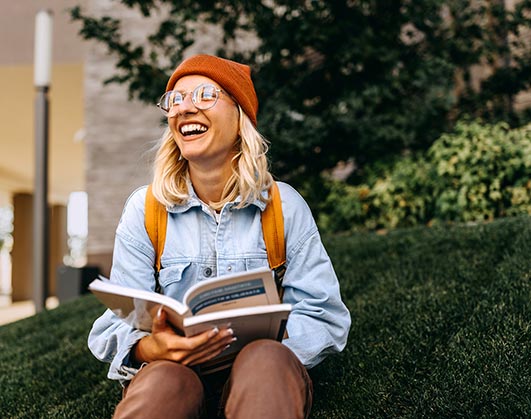College student reading book on campus