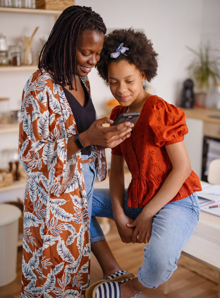 Mother and daughter looking at checking accounts on phone