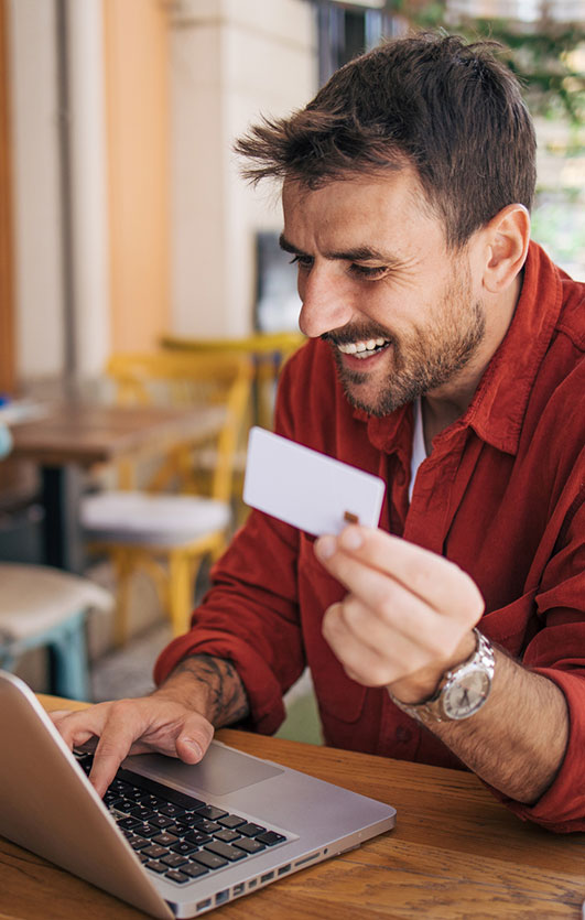 Man using debit card while online shopping