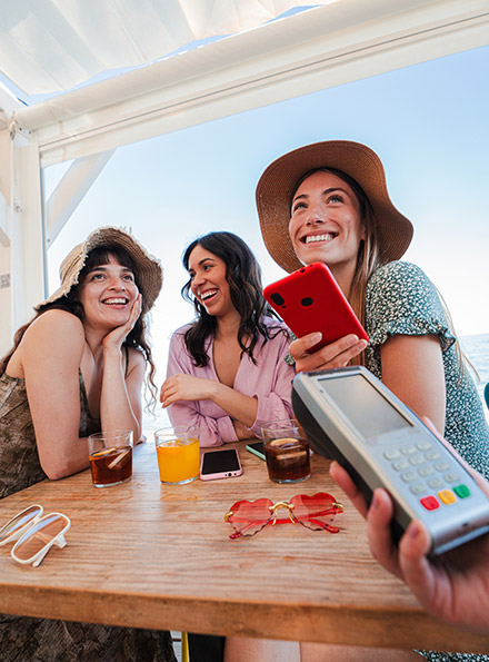 Teens paying with phone at restaurant