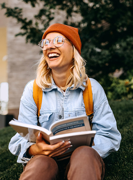 College student reading books on campus